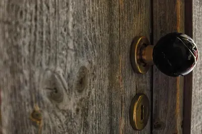 an old wooden door with a knob on it at Hôtel E Tre Stelle in Bonifacio