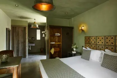 a bedroom with a large bed and a bathroom at Hôtel E Tre Stelle in Bonifacio