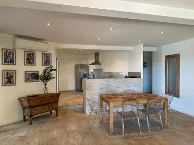 a kitchen and dining room with a wooden table and chairs at Residence Casa Di Paoli in Porto-Vecchio
