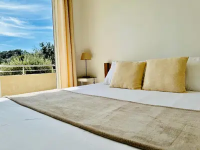 a bedroom with a white bed with a window at Residence Casa Di Paoli in Porto-Vecchio
