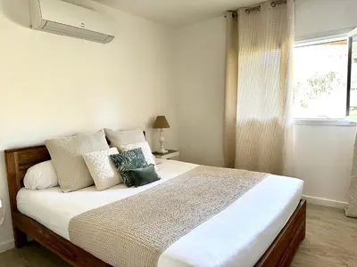 a bedroom with a bed with white sheets and a window at Residence Casa Di Paoli in Porto-Vecchio