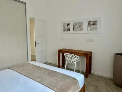 a bedroom with a bed and a desk and a chair at Residence Casa Di Paoli in Porto-Vecchio