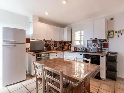 a kitchen with a wooden table and white cabinets at Apartment Casa Marcelli by Interhome in SantʼAntonino