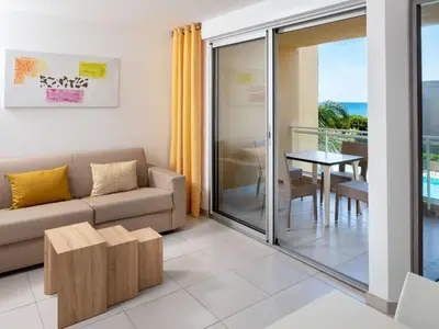 a living room with a couch and a table at Apartment MB4 piscine by Interhome in Moriani Plage