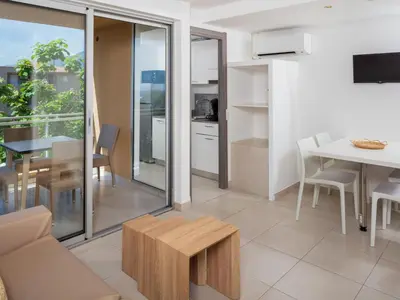 a living room with a couch and a table at Apartment MB4 piscine by Interhome in Moriani Plage