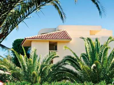 a large blue swimming pool with trees and the ocean at Apartment MB6 sans vue mer by Interhome in Moriani Plage