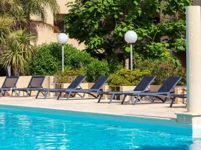 a swimming pool in front of a building at Apartment MB6 sans vue mer by Interhome in Moriani Plage