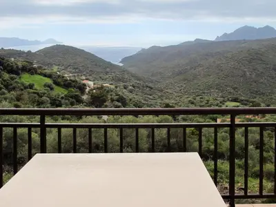 a table on a balcony with a view of mountains at Apartment Fougère by Interhome in Partinello