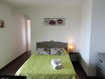 a bedroom with a green bed with towels on it at Apartment Fougère by Interhome in Partinello