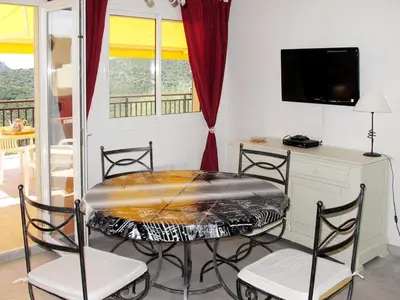 a dining room with a table and chairs and a tv at Apartment Aloes by Interhome in Partinello