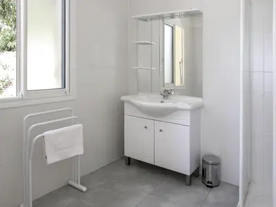 a white bathroom with a sink and a mirror at Apartment Aloes by Interhome in Partinello
