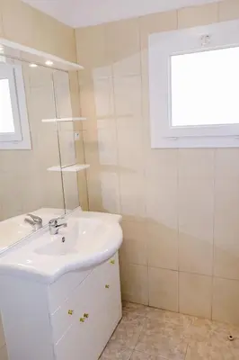 a white bathroom with a sink and a mirror at Apartment Camelia- Marjolène by Interhome in Partinello