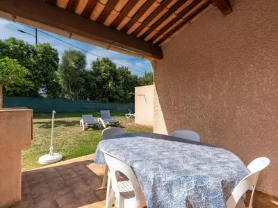 a patio with a table and chairs on a patio at Holiday Home La Pinède- bungalow 4 pers- by Interhome in Sagone