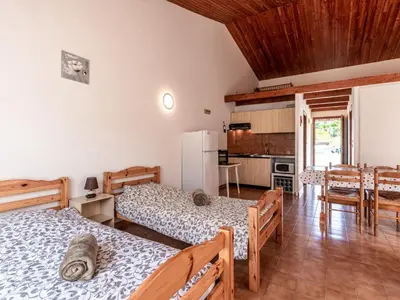 a living room with two beds and a kitchen at Holiday Home La Pinède- bungalow 4 pers- by Interhome in Sagone