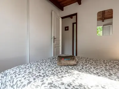 a white bedroom with a bed with a bag on it at Holiday Home La Pinède- bungalow 6 pers- by Interhome in Sagone