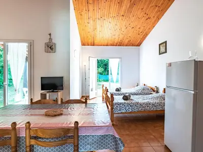 a living room with two beds and a refrigerator at Holiday Home La Pinède- bungalow 6 pers- by Interhome in Sagone