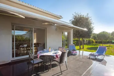 a patio with a table and chairs on it at Villa Jardins de la Mer in Poggio-Mezzana
