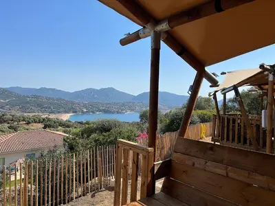 a wooden porch with a view of a lake at Residence Piatana in Olmeto