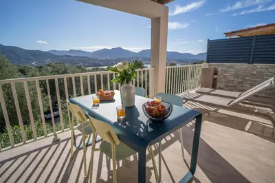 a blue table with a bowl of fruit on a balcony at Residence Piatana in Olmeto