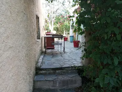 an alley with a table and chairs in a building at Villa Trou Aux Biches in Oletta