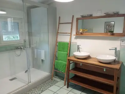 a bathroom with two sinks and a shower at Villa Trou Aux Biches in Oletta