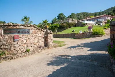 a stone wall with a sign that reads residence rental at Résidence U Pirellu in Porto-Vecchio