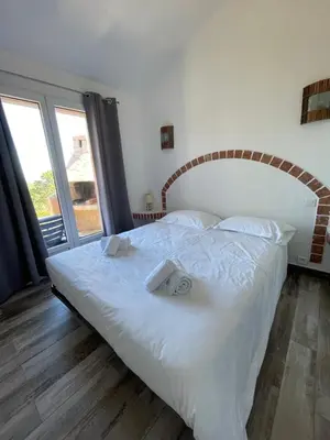 a bedroom with a large white bed with towels on it at Résidence U Pirellu in Porto-Vecchio