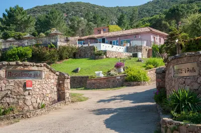 a house on a hill with a stone wall at Résidence U Pirellu in Porto-Vecchio