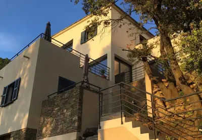 a white house with stairs and a tree at A Casa Di Campa in Oletta
