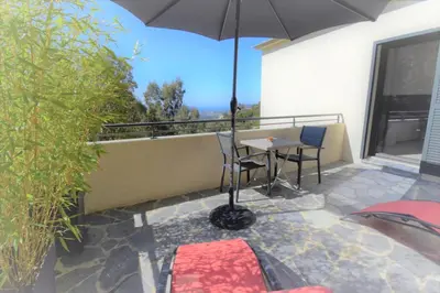 a patio with an umbrella and a table and chairs at A Casa Di Campa in Oletta