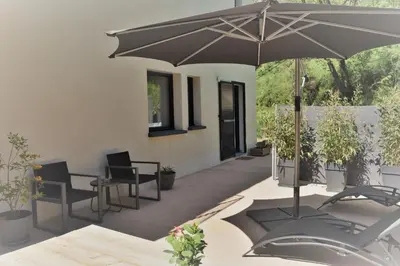 a patio with a table and an umbrella at A Casa Di Campa in Oletta