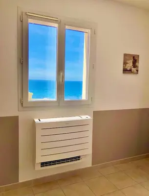 a white dresser in a room with a window at L'armandulina in Sagone