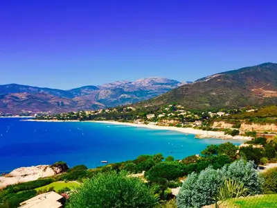 a view of a beach with mountains in the background at L'armandulina in Sagone