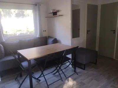 a living room with a table and a couch at Camping Les Eaux Vives in Vero