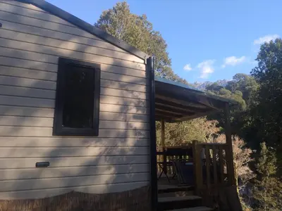 a side view of a house with a porch at Camping Les Eaux Vives in Vero