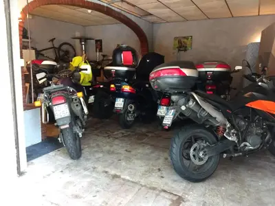a group of motorcycles parked in a garage at Hotel & Restaurant Le Beau Sejour in Porto Ota