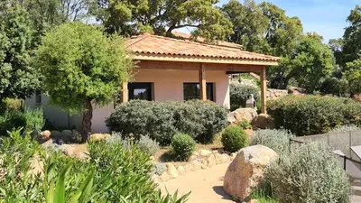 a small house in a garden with bushes at Villas Lantana in Porto-Vecchio