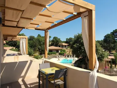 a patio with a table and chairs and a swimming pool at Villas Lantana in Porto-Vecchio