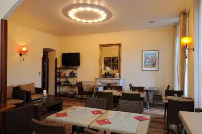 a restaurant with tables and chairs and a fireplace at Hôtel Duc De Padoue in Corte