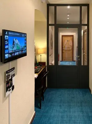a room with a door with a television on a wall at Hôtel Duc De Padoue in Corte