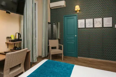 a hotel room with a bed and a green door at Hôtel Duc De Padoue in Corte