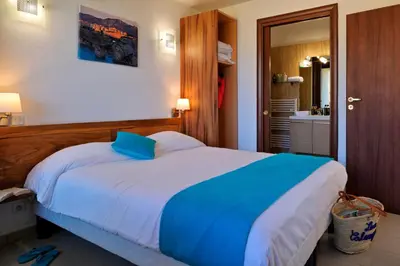 a bedroom with a bed with a blue pillow on it at Résidence Les Calanques in Ajaccio