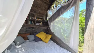 a bed in a tent with a window at A Cantina Chalet avec Piscine proche d Ajaccio in Carbuccia