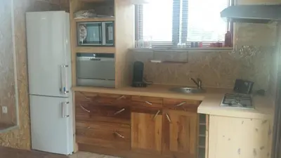 a kitchen with a white refrigerator and a sink at A Cantina Chalet avec Piscine proche d Ajaccio in Carbuccia