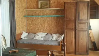 a bed with pillows on it in a room at A Cantina Chalet avec Piscine proche d Ajaccio in Carbuccia