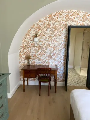 a bedroom with a desk and a wall at Hôtel U Frascone in Venaco