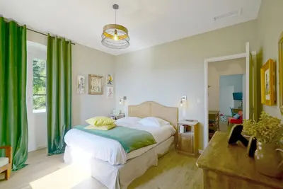 a bedroom with a bed with green curtains at Hôtel U Frascone in Venaco