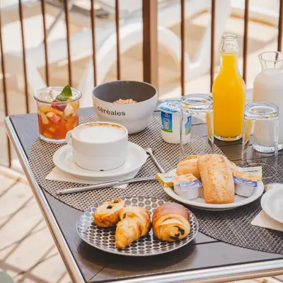 a table topped with plates of pastries and orange juice at Casa Marana by Le Lido in Lucciana
