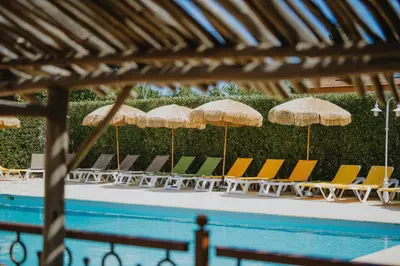 a group of chairs and umbrellas next to a swimming pool at Casa Marana by Le Lido in Lucciana