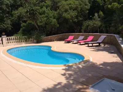 a swimming pool with two chairs and a swimming poolvisor at Gites Ugliastru PORTICCIO in Eccica-Suarella